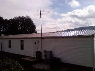 New metal roof on a single wide mobile home with a TV antenna in Stanley